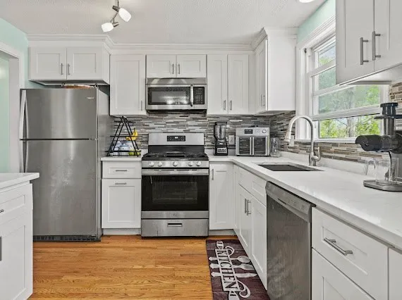 a kitchen with a sink a stove a microwave and refrigerator