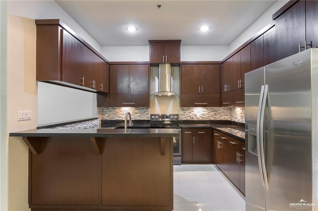 3016 South L Street, Unit 2 McAllen, TX 78503 - Photo 3 of 10 a kitchen with stainless steel appliances granite countertop a sink a stove and a refrigerator