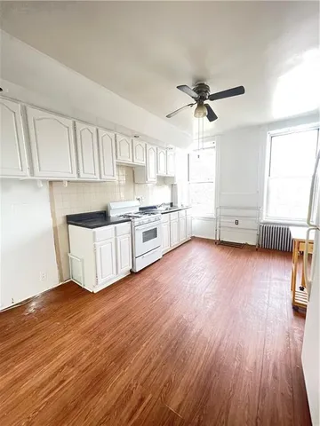 a view of kitchen with cabinets wooden floor and a sink