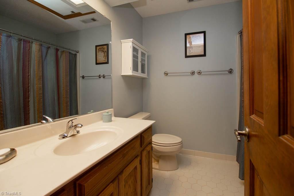 6520 Hollow River Drive Oak Ridge, NC 27310 - Photo 22 of 26 Upper hall bath with ceramic tile flooring and tub/shower combination.