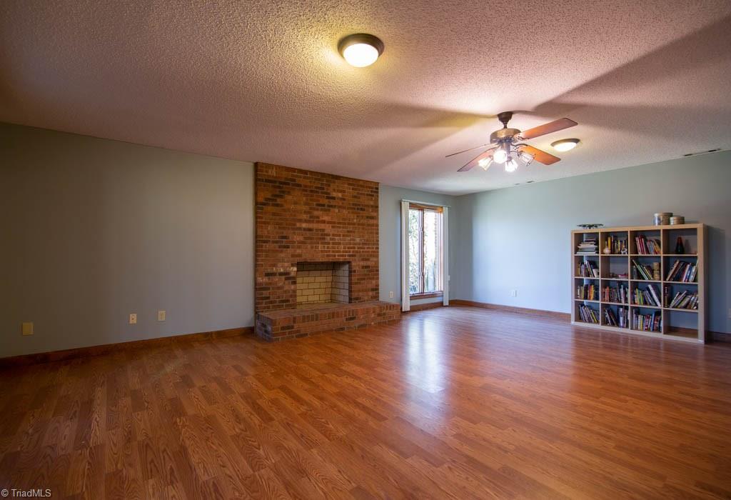 6520 Hollow River Drive Oak Ridge, NC 27310 - Photo 23 of 26 Finished basement with wood-buring fireplace and access to a covered porch.