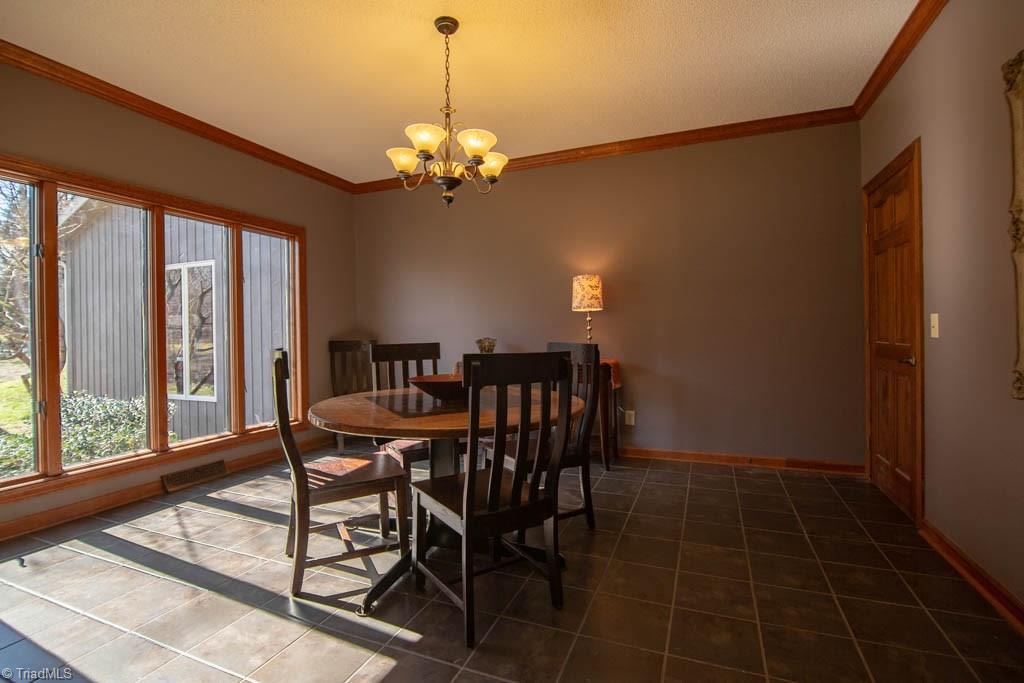 6520 Hollow River Drive Oak Ridge, NC 27310 - Photo 5 of 26 Formal dining room with ceramic tile floor and beautiful windows.