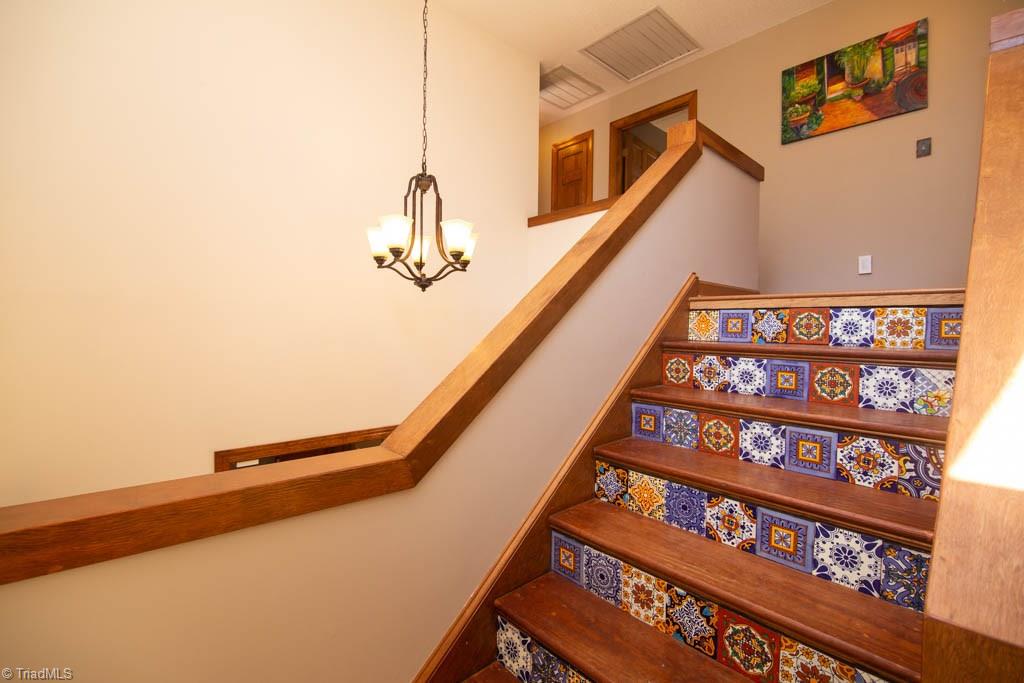 6520 Hollow River Drive Oak Ridge, NC 27310 - Photo 6 of 26 Stair well with decorative ceramic tile rise and wood treads.