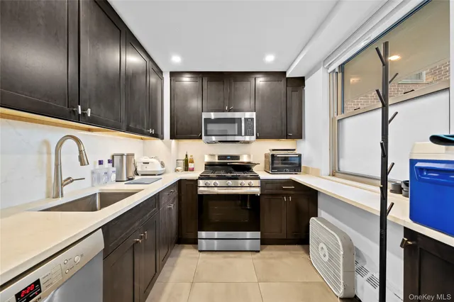a kitchen with stainless steel appliances granite countertop a stove sink and cabinets