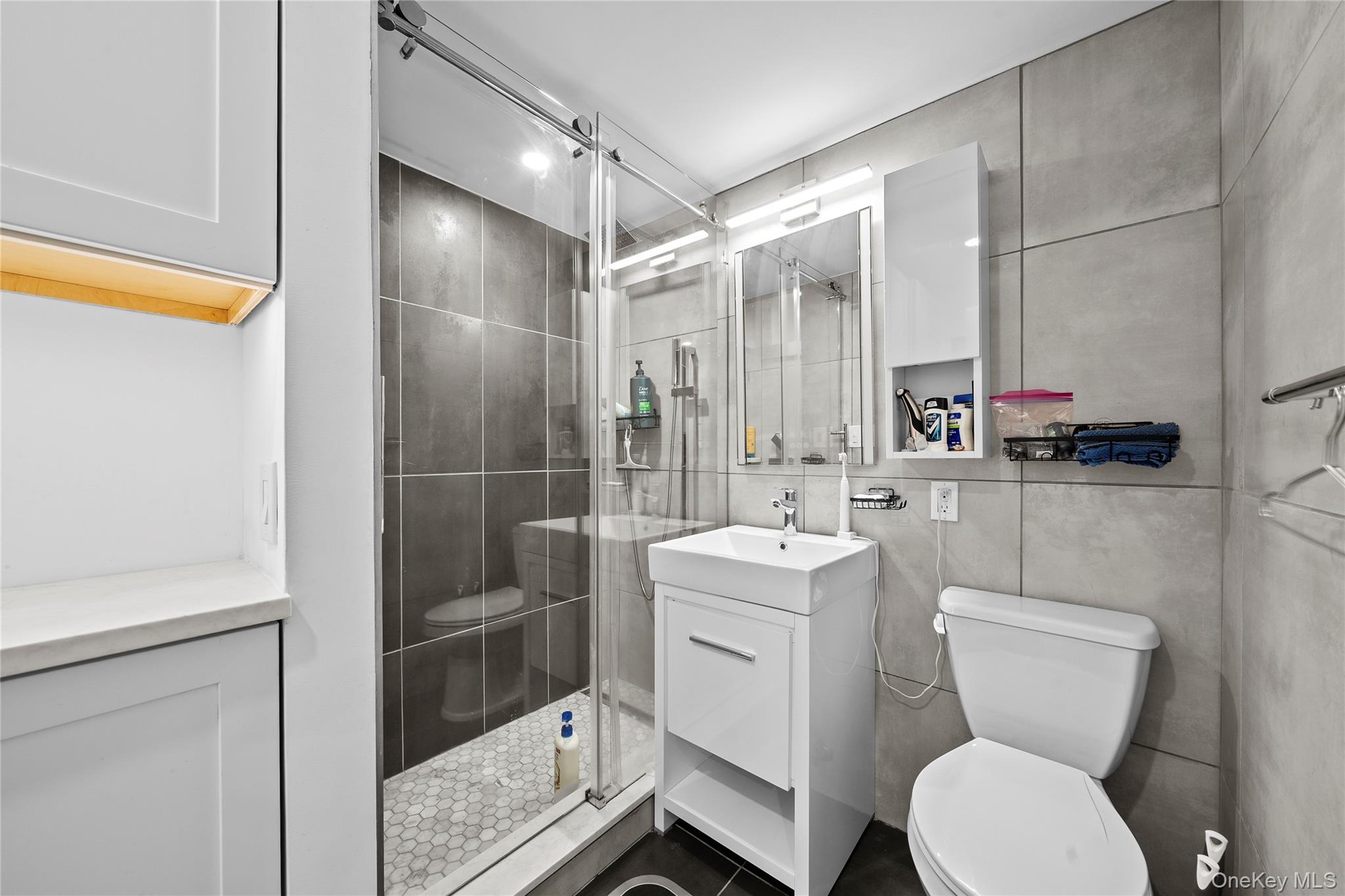 61-25 97th Street, Unit 12M Queens, NY 11374 - Photo 10 of 24 a bathroom with a toilet sink and mirror