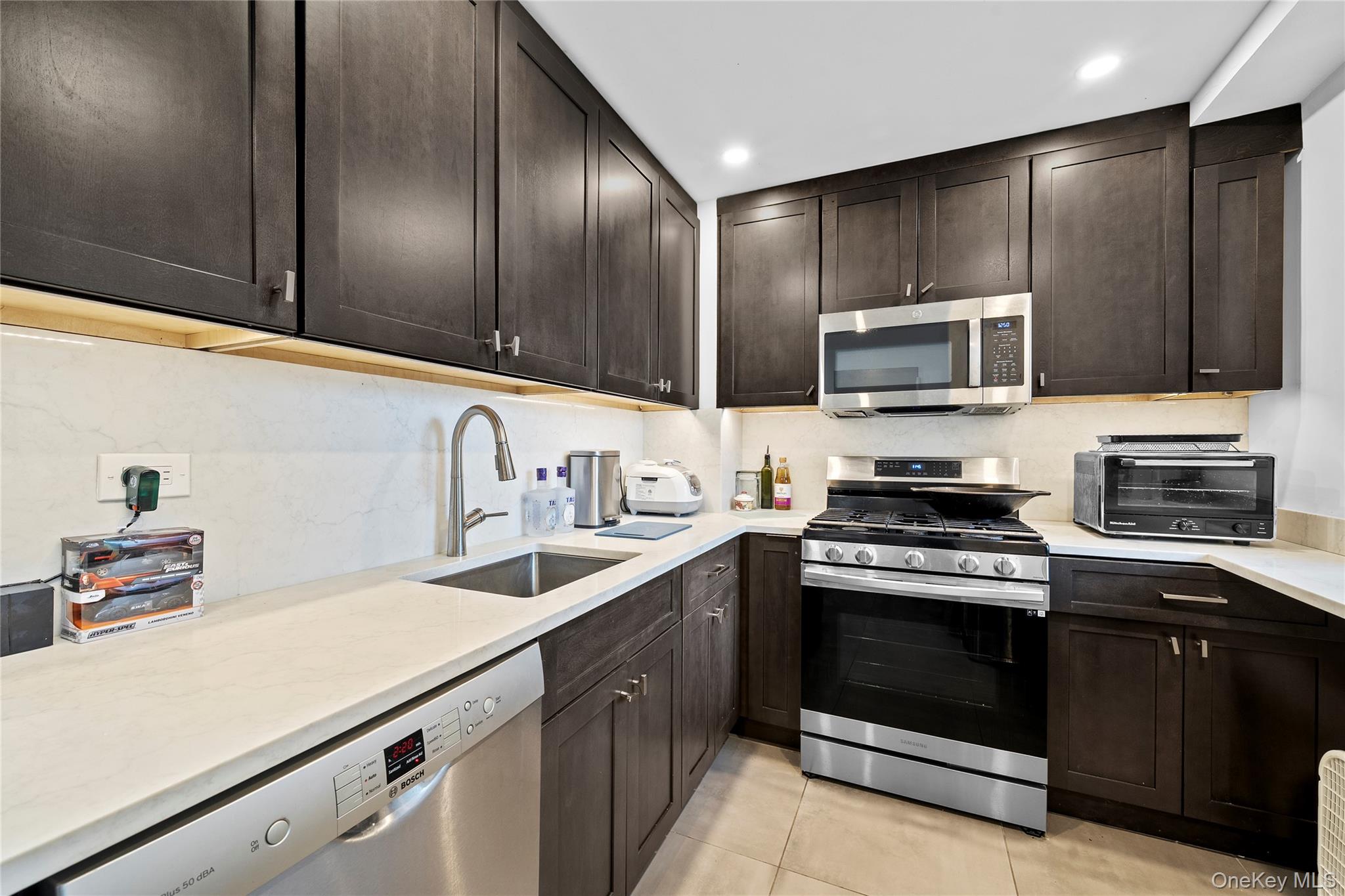 61-25 97th Street, Unit 12M Queens, NY 11374 - Photo 6 of 24 a kitchen with a sink stove and microwave