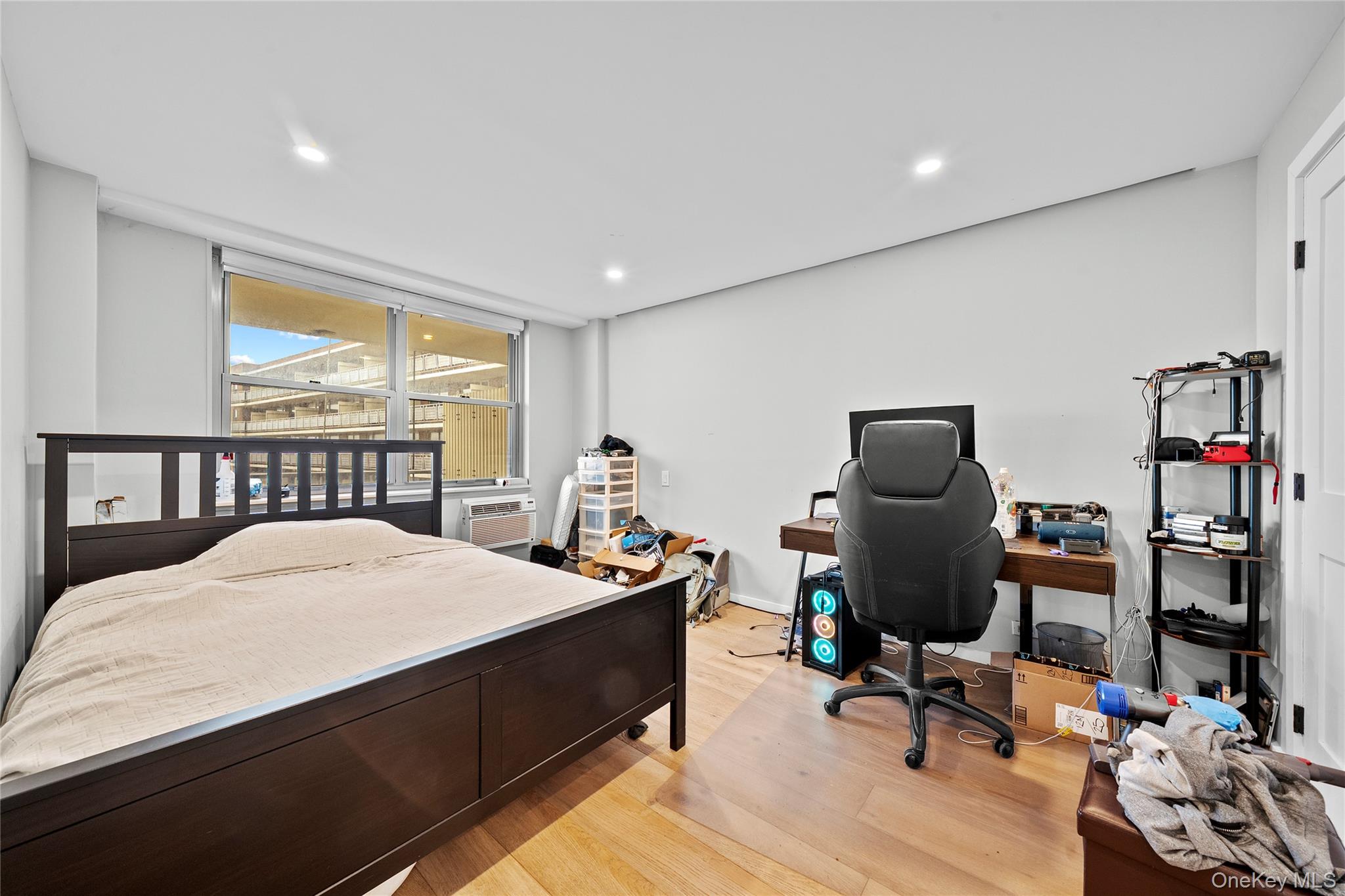 61-25 97th Street, Unit 12M Queens, NY 11374 - Photo 9 of 24 a bedroom with a bed a desk and chair with window