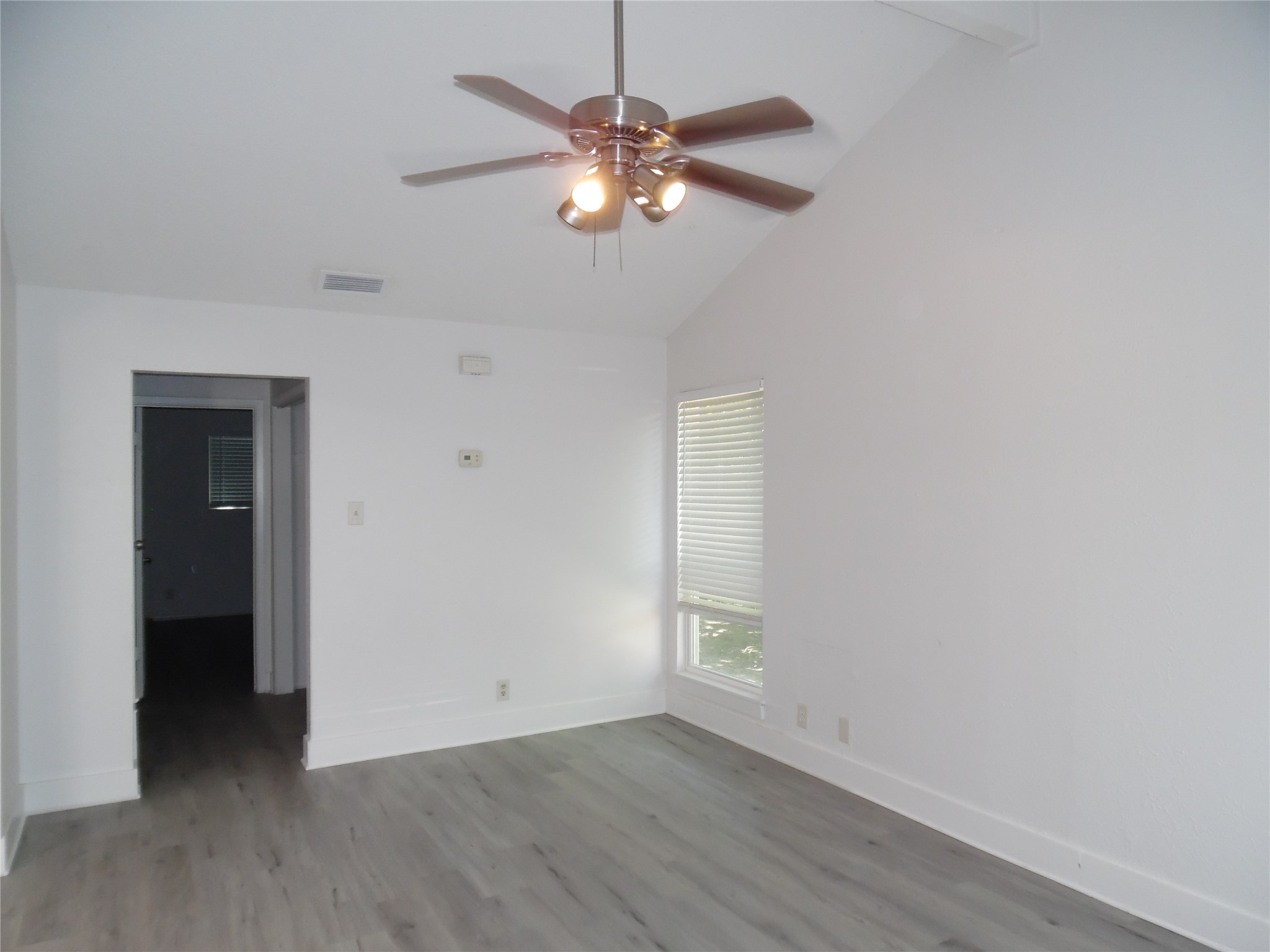 7400 Dixie Drive, Unit B Austin, TX 78744 - Photo 4 of 15 Vaulted ceiling with an attached ceiling fan, wood-finish flooring, and crisp white walls