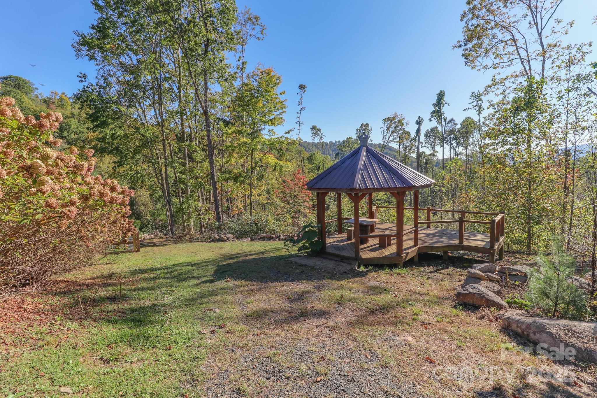 2811 Poplar Creek Road Green Mountain, NC 28740 - Photo 28 of 35 a view of patio with a table and chairs under an umbrella