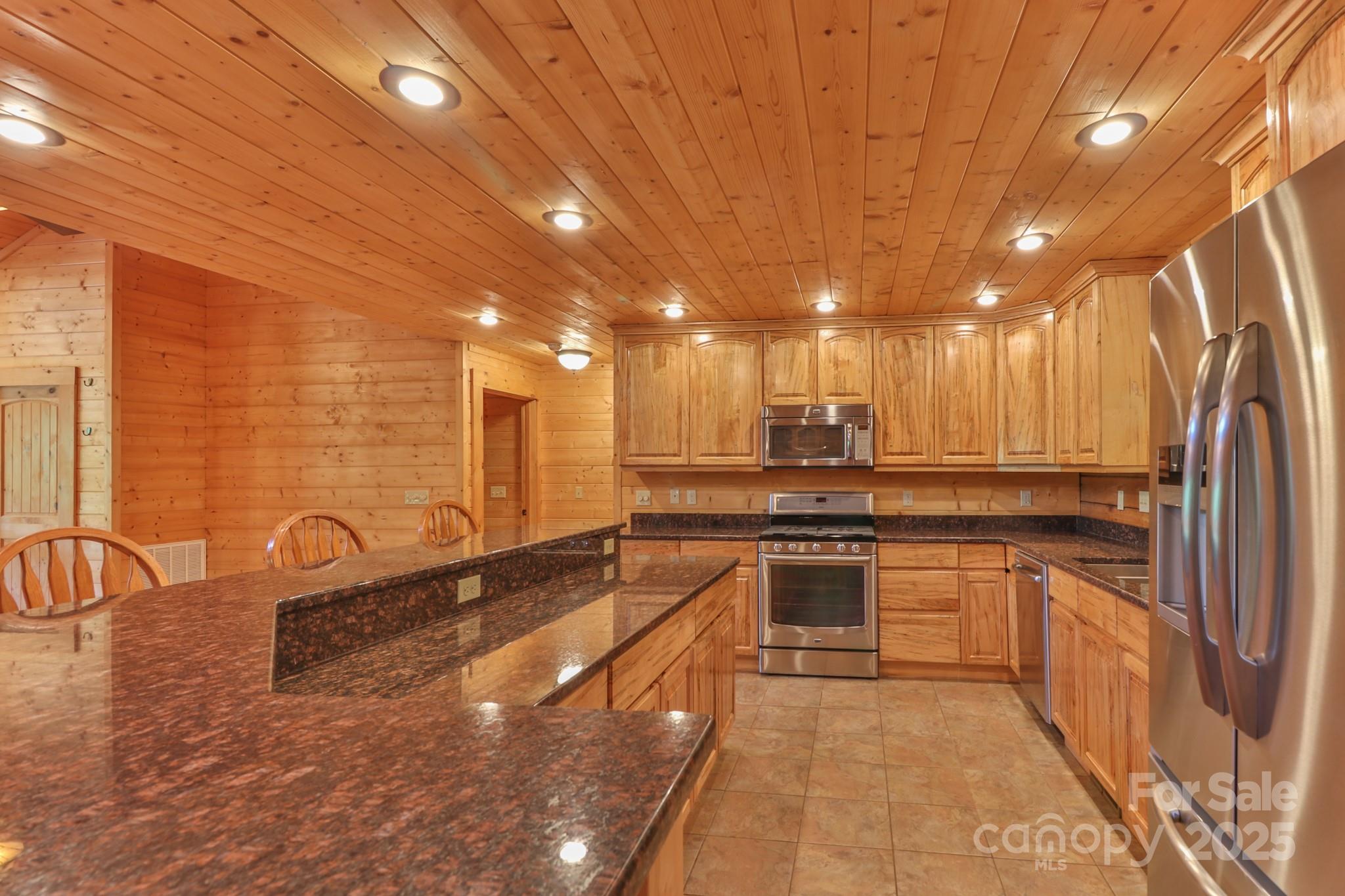2811 Poplar Creek Road Green Mountain, NC 28740 - Photo 7 of 35 a large kitchen with kitchen island a sink stainless steel appliances and cabinets