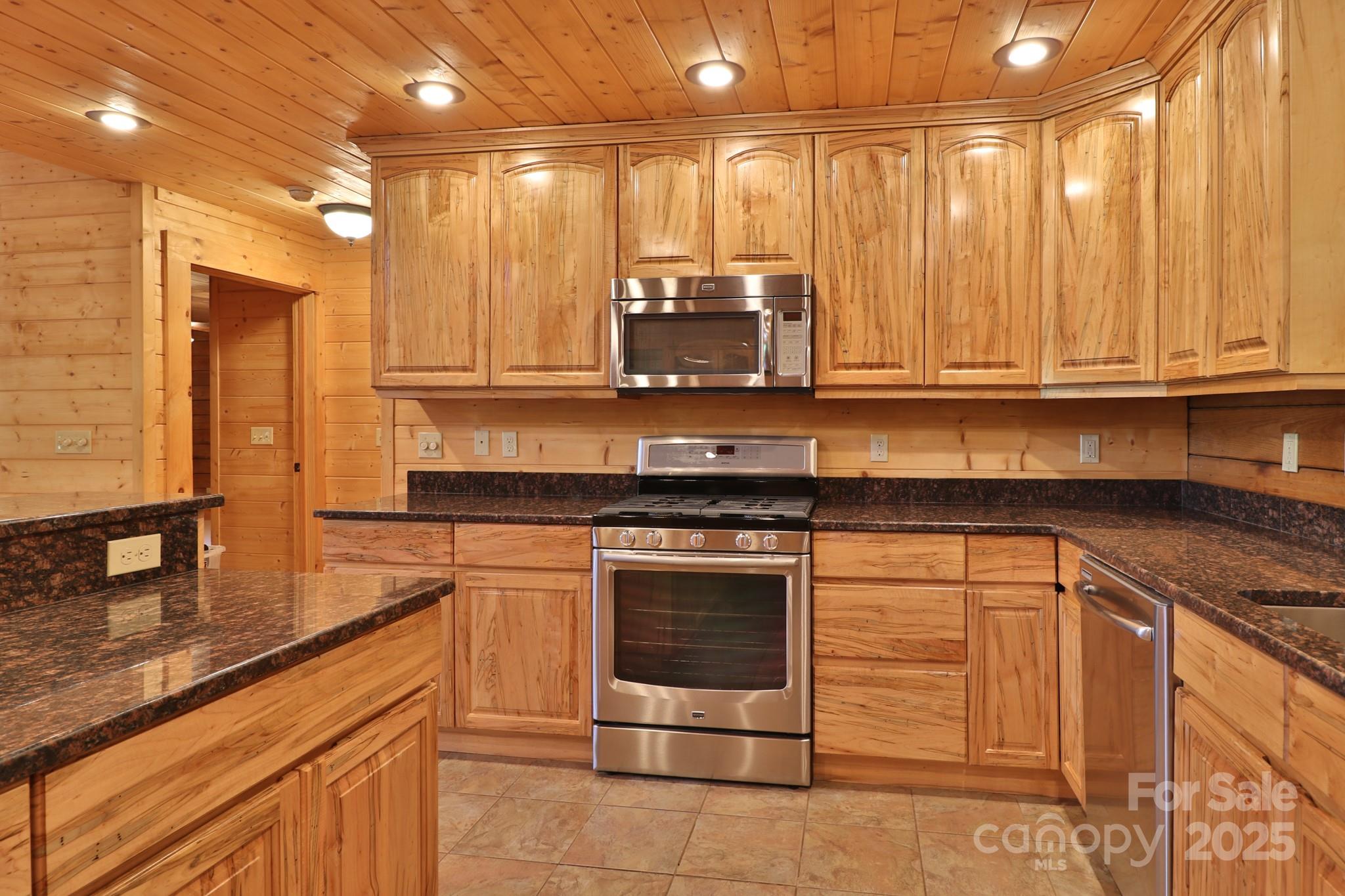 2811 Poplar Creek Road Green Mountain, NC 28740 - Photo 9 of 35 a kitchen with stainless steel appliances granite countertop a stove a sink and a microwave
