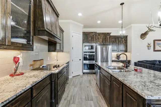 a kitchen with stainless steel appliances granite countertop a sink stove and refrigerator