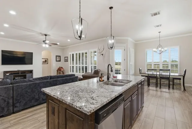 a kitchen with granite countertop kitchen island a sink and a stove