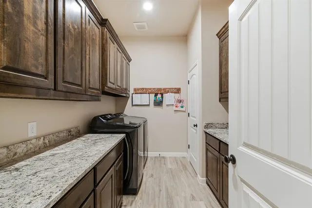 a kitchen with granite countertop a sink a stove oven and cabinetry