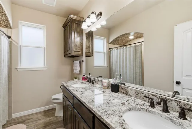 a bathroom with a granite countertop sink a large mirror and vanity