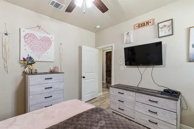 a living room with flat screen tv on the wall and dresser