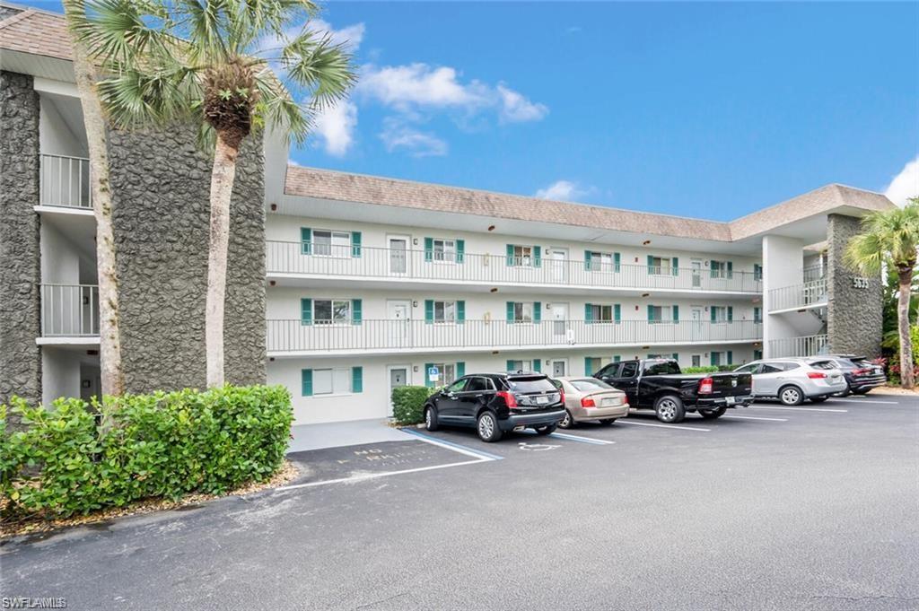5635 Rattlesnake Hammock Road, Unit D203 Naples, FL 34113 - Photo 7 of 8 a cars parked in front of a building