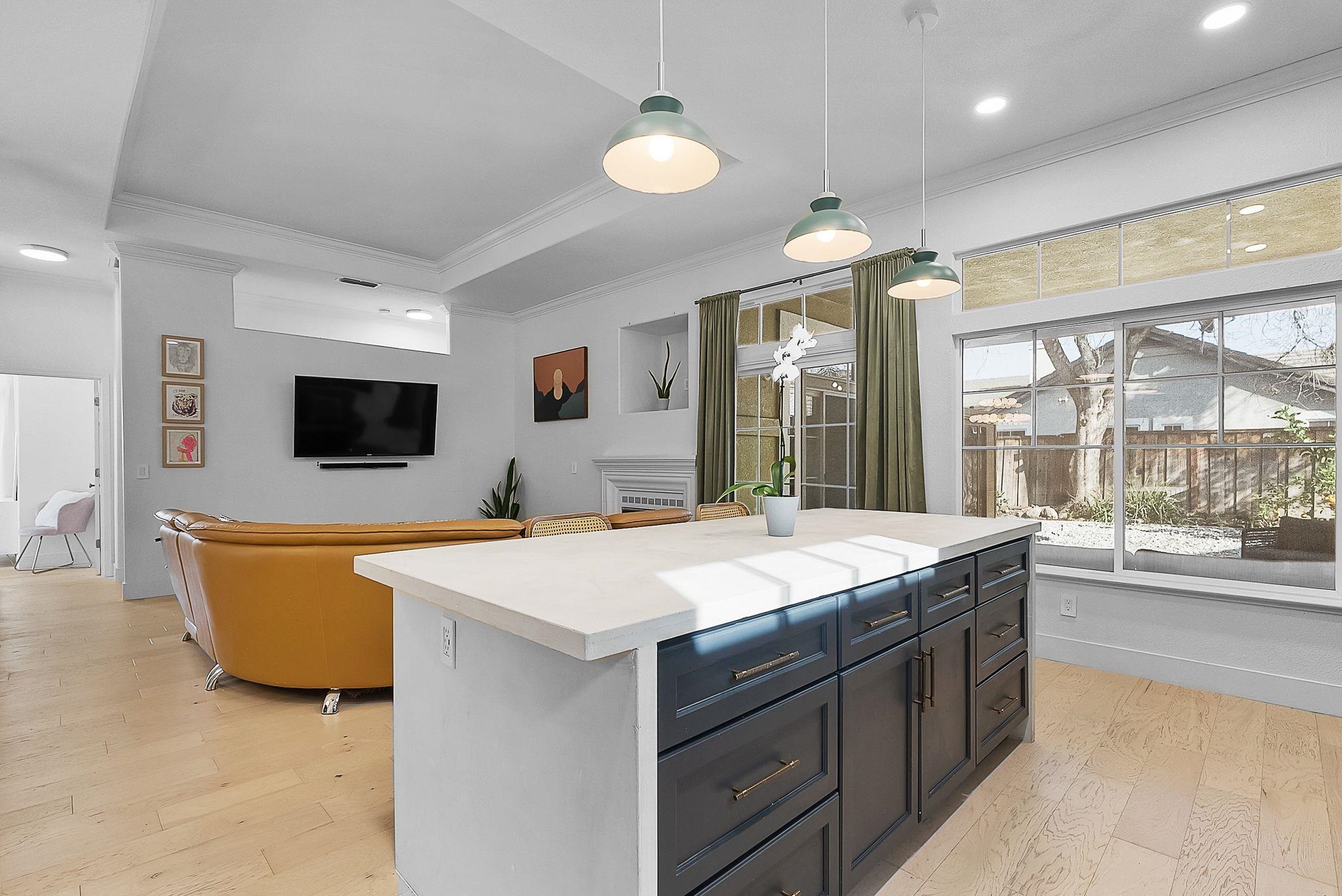 536 Birchwood Road Brentwood, CA 94513 - Photo 16 of 45 Kitchen featuring light countertops, pendant lighting, light wood finished floors, crown molding, and a kitchen island