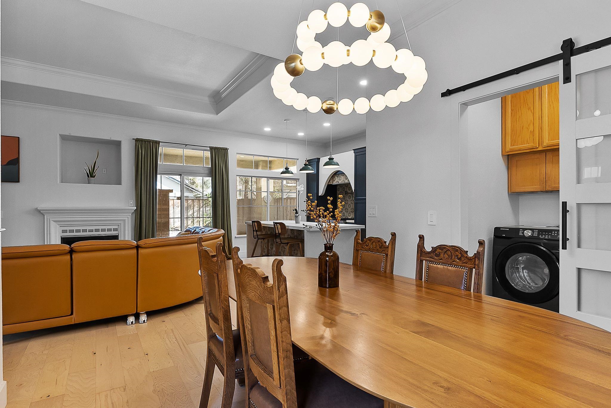 536 Birchwood Road Brentwood, CA 94513 - Photo 7 of 45 Dining space with washer / clothes dryer, light wood-style floors, crown molding, suspended lighting, and a barn door