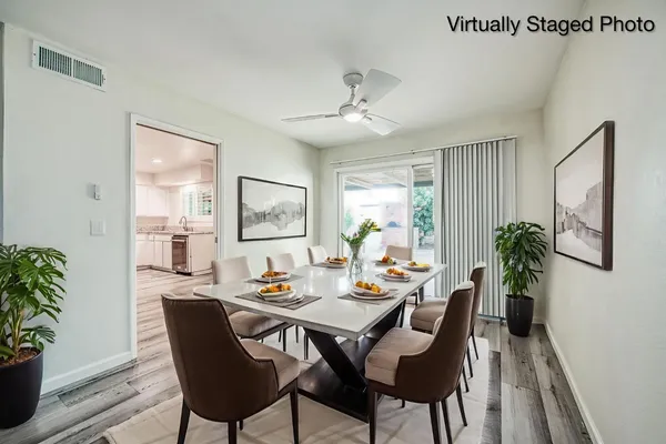 a kitchen with white cabinets and wooden floor