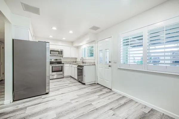 a kitchen with stainless steel appliances granite countertop a sink stove and microwave