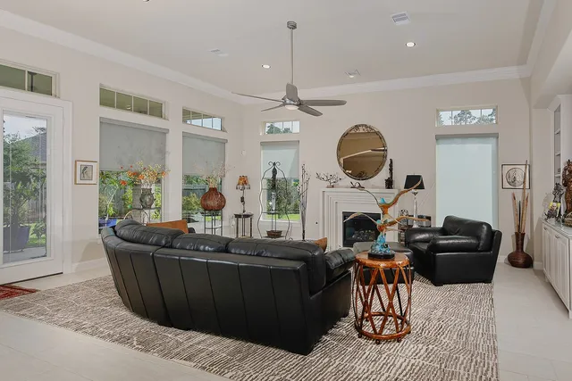a living room with furniture a fireplace and a large window