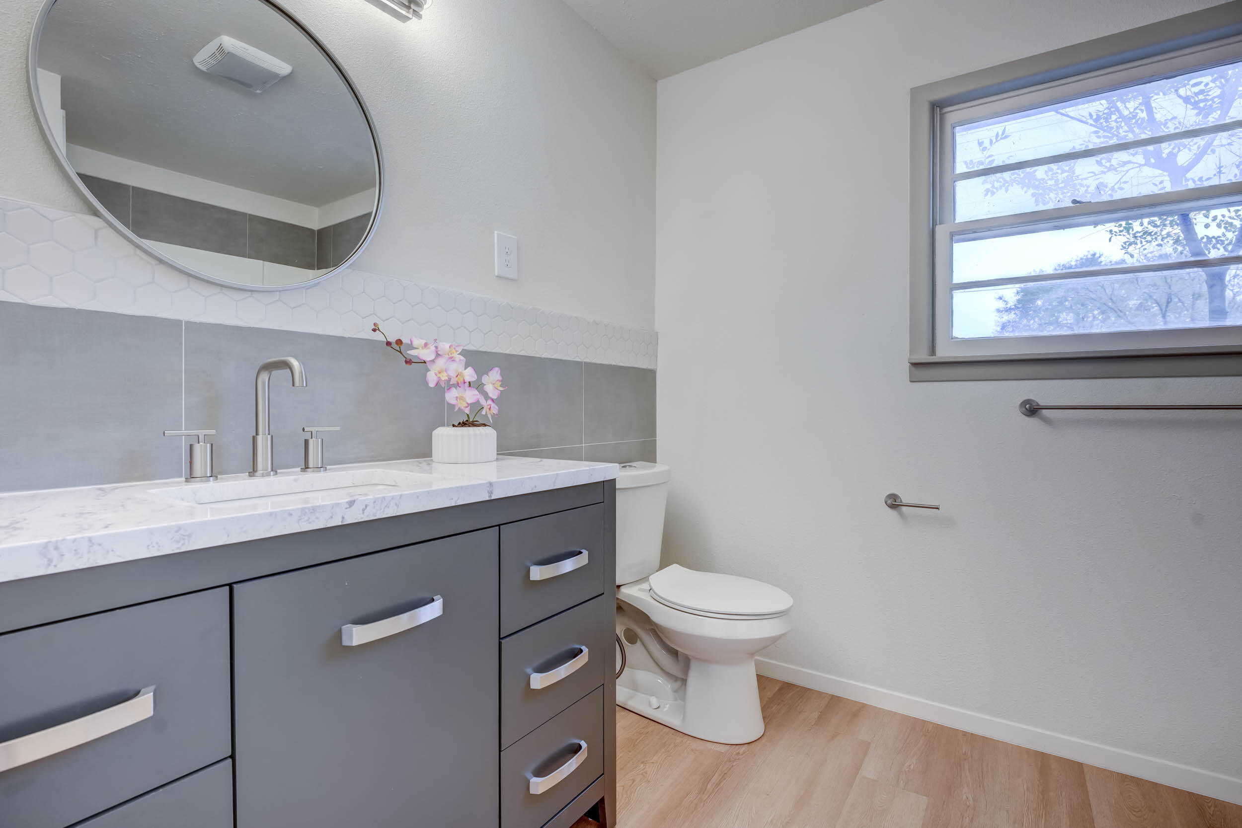 2101 64th Street Lubbock, TX 79412 - Photo 5 of 30 a bathroom with a granite countertop toilet sink and mirror