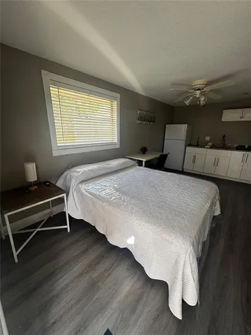 a kitchen with granite countertop a sink a stove a refrigerator and white cabinets