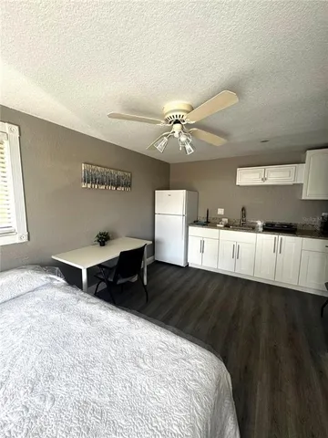 a view of a livingroom with wooden floor and electronic appliances