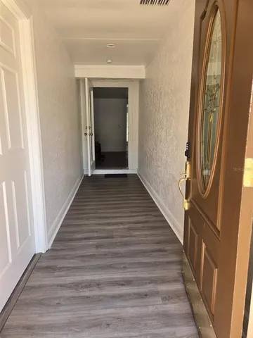 a view of a hallway with wooden floor and staircase
