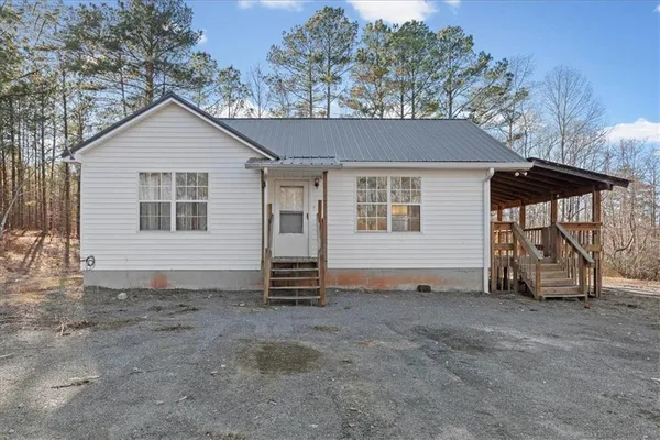 a view of a house with a yard and sitting area
