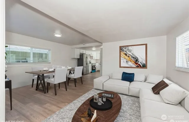 a living room with furniture two window and a table