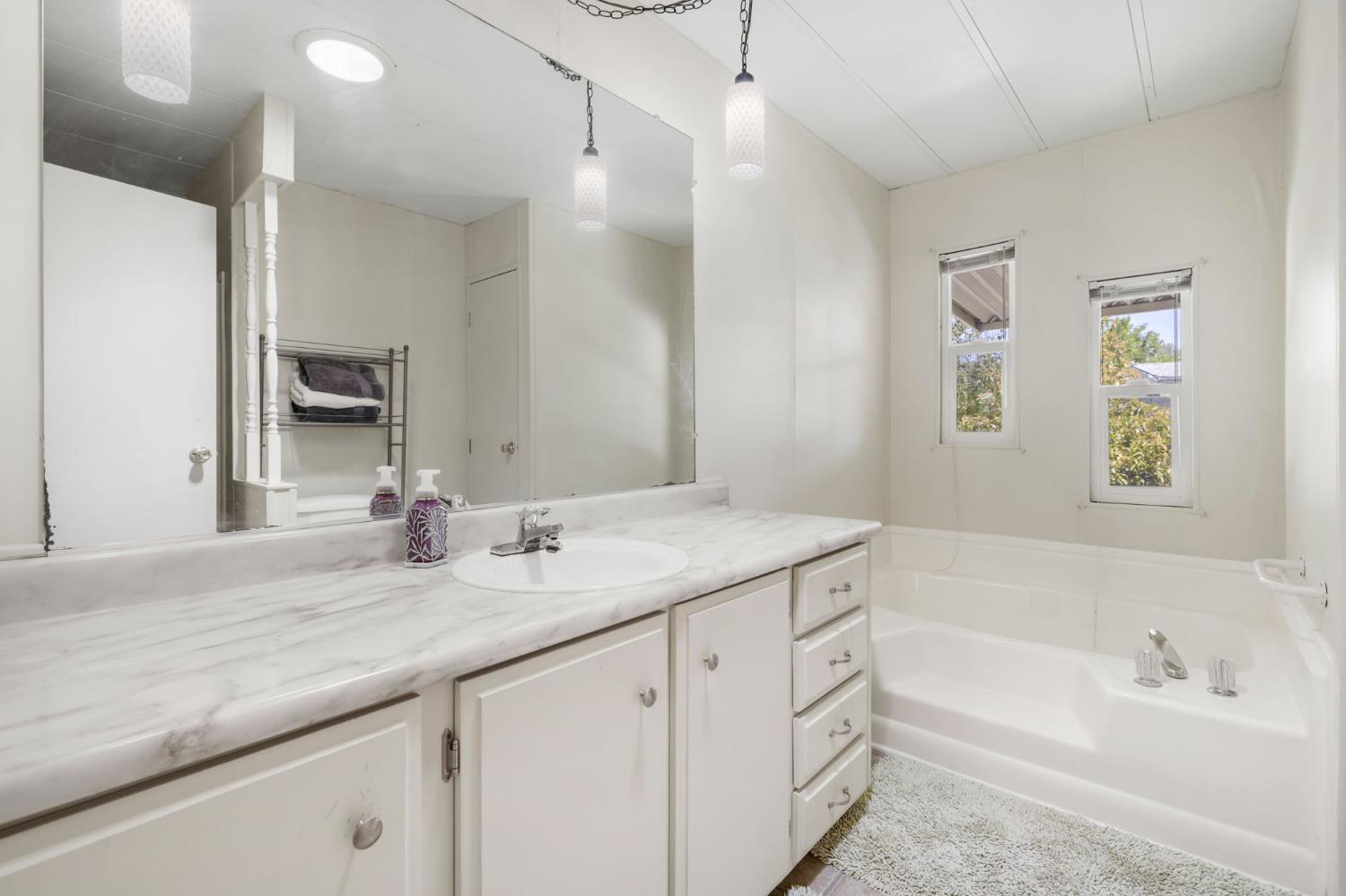 4700 Old French Town Road, Unit 64 Shingle Springs, CA 95682 - Photo 14 of 26 a bathroom with a granite countertop sink mirror and a bath tub