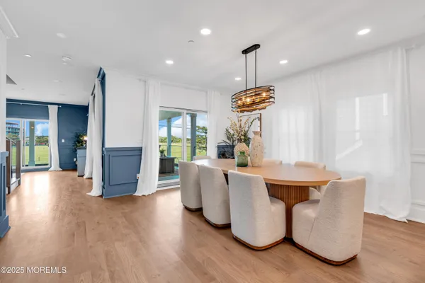 a living room with couches a table and chairs with wooden floor