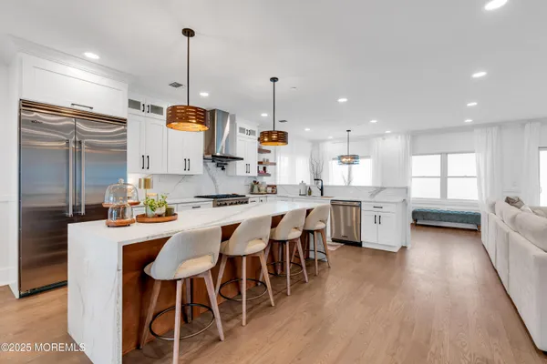 a kitchen with stainless steel appliances kitchen island granite countertop a sink table and chairs