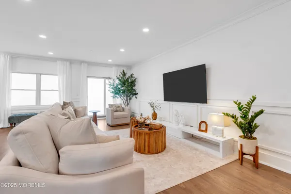 a living room with furniture a flat screen tv and a potted plant