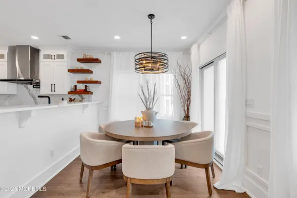 a dining room with furniture a chandelier and wooden floor