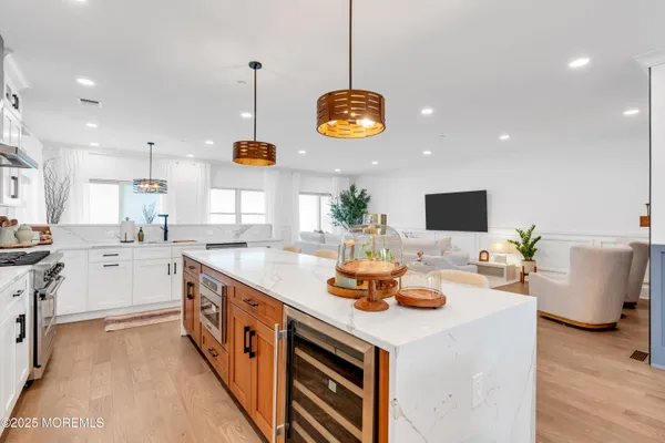 a kitchen with stainless steel appliances kitchen island granite countertop a sink a stove and a wooden floors