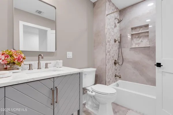 a bathroom with a sink toilet vanity and shower