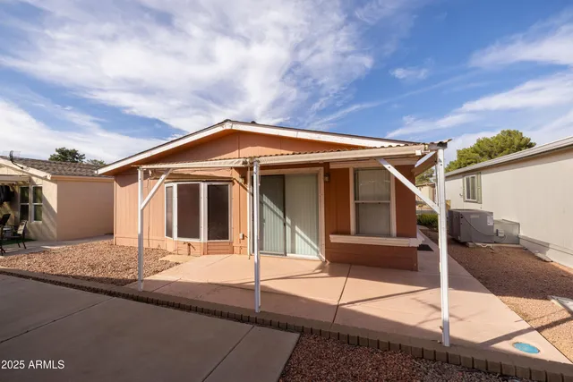 a blue and white house with a large window and wooden fence