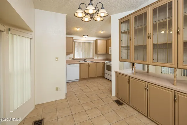 a large white kitchen with a sink and dishwasher a stove with wooden floor