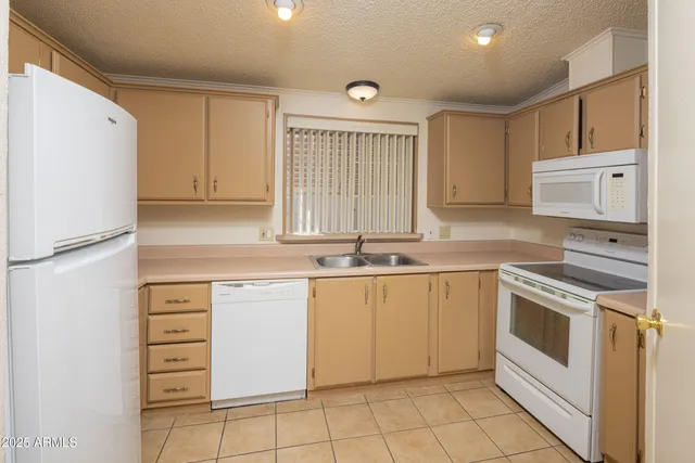 a kitchen with granite countertop white cabinets and white appliances