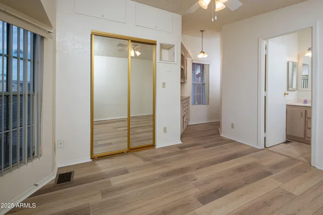 an empty room with wooden floor and a bathroom
