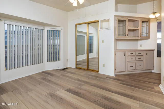an empty room with wooden floor and windows