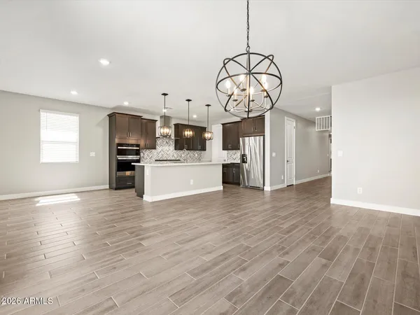 an empty room with wooden floor a ceiling fan and window