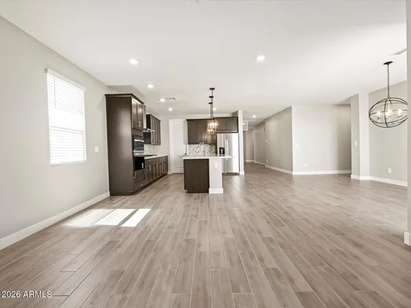 a view of a kitchen with wooden floor and stainless steel appliances