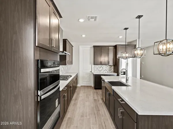 a kitchen with stainless steel appliances granite countertop a stove a sink and a refrigerator