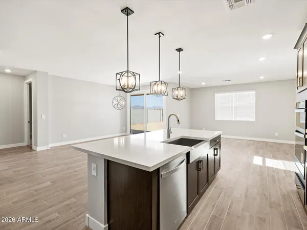 a kitchen with stainless steel appliances granite countertop a sink a counter space and wooden floor