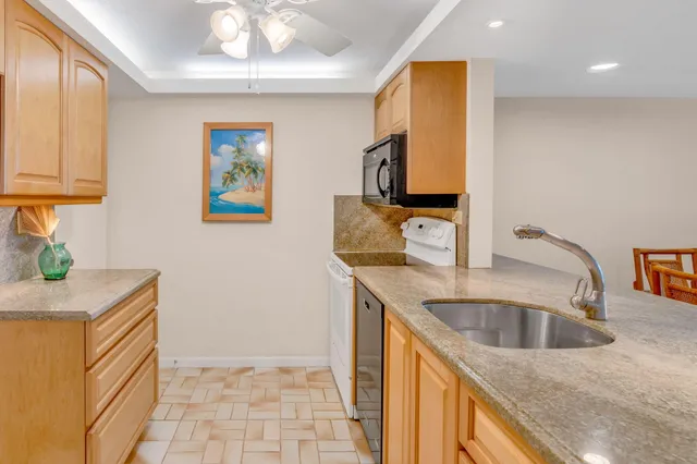 a kitchen with stainless steel appliances granite countertop a sink and a refrigerator