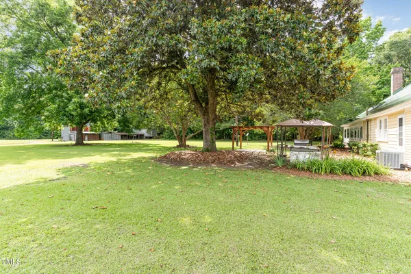 a front view of a house with a yard and trees
